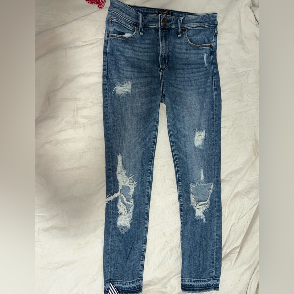 Distressed blue jeans with distressed bottoms slim fit